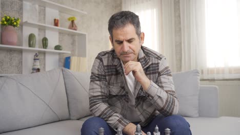 Close-up-of-lonely,-thoughtful-and-unhappy-man-playing-chess-alone.